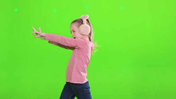 受到启发的女舞蹈演员跳着 摇晃着 在工作室里跳着 眼前的景象是快乐的高加索女孩穿着粉色耳罩跳舞 欣赏着音乐 与绿色背景隔离 休闲的概念 — 图库视频影像