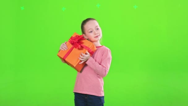 Любопытная Девочка Трясет Завернутую Праздничную Подарочную Коробку Угадывая Внутри Вид — стоковое видео