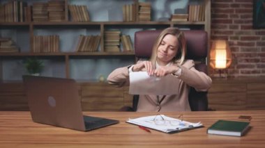 Young ceo being pissed off after reading papers about company debts, ripping documents and looking at personal computer. Formally dressed elegant woman feeling stress and despair.