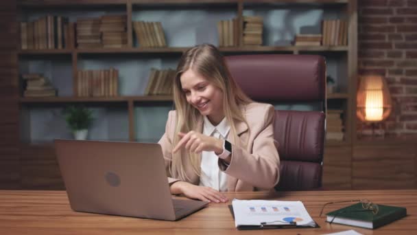 积极员工邀请同事参加在线视频会议的笔记本电脑 快乐的女性坐在舒适的办公椅上 手拿着欢迎的手势 — 图库视频影像