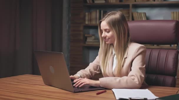 美丽的金发女子在网上娱乐 与朋友在网上交流 面带微笑 天使般的视角 迷人的女士在华丽的办公室里使用个人笔记本电脑 — 图库视频影像