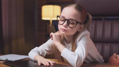 Beyaz bluzlu, gözlüklü, çok çalışan ve rahat bir ofiste dizüstü bilgisayarı kapatan beyaz bir kız. Yorgun, ergen bir çocuk masaya kıvrılıp uykuya dalıyor..