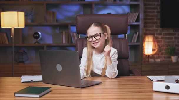 電子メールで予期せぬ良いニュースを読んで喜びの小さな女性 ノートパソコンを閉じて 屋内で仕事の昇進を喜びます 興奮して腕を上げて勝利ジェスチャーを示す感情的な十代の女の子 — ストック動画