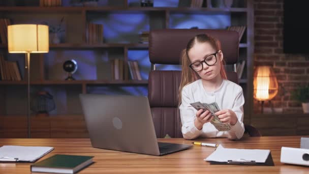 オフィスのデスクでリモートコンピュータの前に座っている間に白いシャツに身を包んだかなり小さなビジネス女性 可愛いです子供で眼鏡をかける時間で父作業スペース — ストック動画