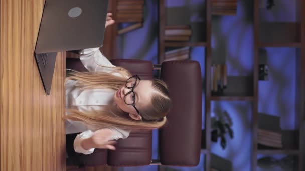 未完成のプロジェクトのために感情的なビジネスの子供はオフィスの従業員に叫んで手を振っています 創造的な職場でラップトップの前に座っている女の子の垂直ビデオ — ストック動画