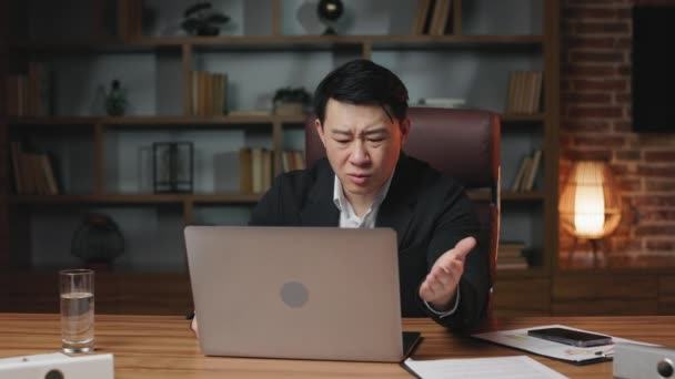 オフィスでワイヤレスノートパソコンを操作し オンラインプログラムで問題に直面している匿名のオフィス従業員 怒りを表す中年のアジア人男性と欲求不満で手をジェスチャー — ストック動画
