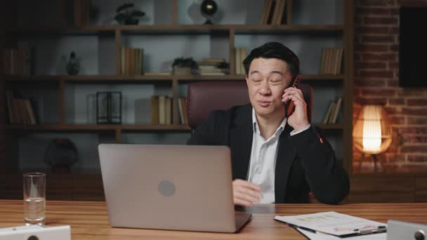 Trabajador Asiático Mediana Edad Sentado Frente Portátil Inalámbrico Oficina Hablando — Vídeos de Stock
