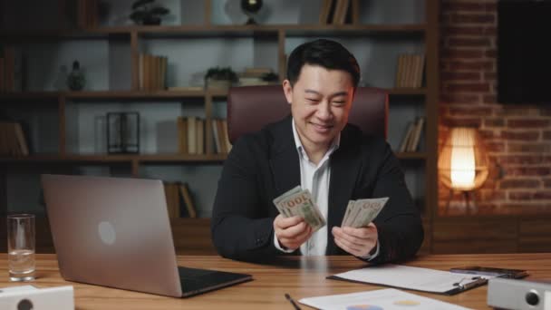 現代の職場でドル紙幣を数える笑みを浮かべてビジネスマンの正面図 成功したアジアの幹部は良い取引を喜び 簡単なお金を稼ぐ 金融の概念 — ストック動画