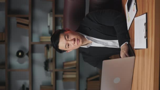 Vertikal Video Asiatisk Man Företagskläder Arbetar Bärbar Dator Vid Skrivbordet — Stockvideo
