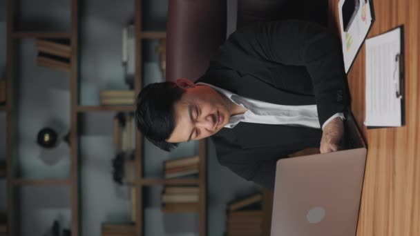 Vertikální Video Pozitivního Asijského Zaměstnance Přistupujícího Přenosnému Počítači Při Výkonu — Stock video