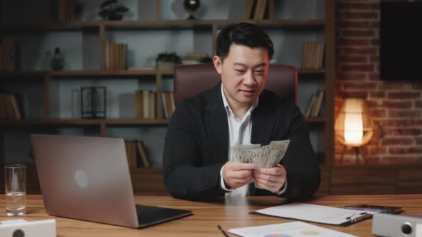 Asiatisk Bankir Klädd Svart Formell Kostym Räkna Kontanter Medan Sitter — Stockvideo