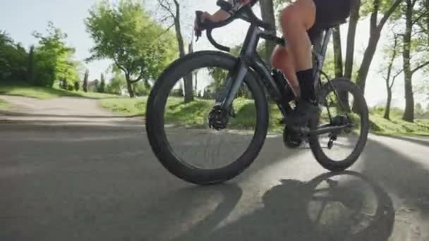 在城市公园里 在阳光明媚的日子里 人们可以看到骑自行车的男性骑手在铺好的车道上骑车 穿着紧身衣的高效运动人士在户外进行缓慢的文娱活动 — 图库视频影像