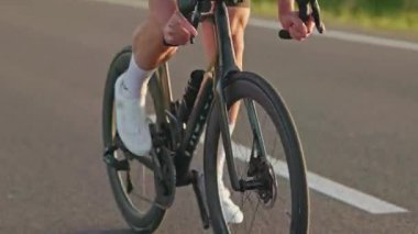 Profesyonel spor aletleri olan genç binici düzgün bir yolda eyerden inerken ritmi artırıyor. Ayaklara eşit basınç uygularken motorsiklet sağa sola sallanıyor..