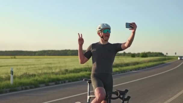 Spännande Cyklist Visar Tummen Upp Och Segerskyltar Medan Tittar Telefon — Stockvideo