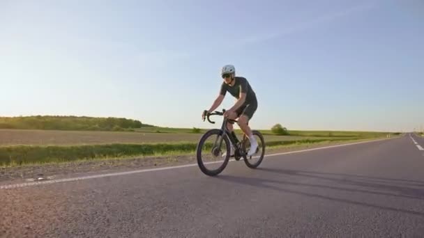 Açık Yol Bisikleti Süren Sporcunun Yaz Günbatımında Kaldırımlı Otoyolda Güçlü — Stok video