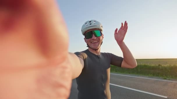 Ciclista Masculino Alegre Capacete Óculos Mostrando Pôr Sol Aplicação Chamada — Vídeo de Stock