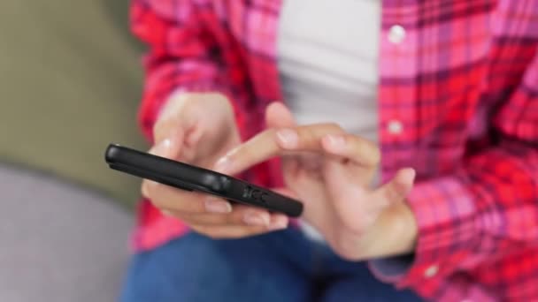 紧紧抓住女性的手 手持黑色现代智能手机和打字信息 穿着牛仔裤和粉色衬衫的女性使用无线网络交流的模糊背景 — 图库视频影像