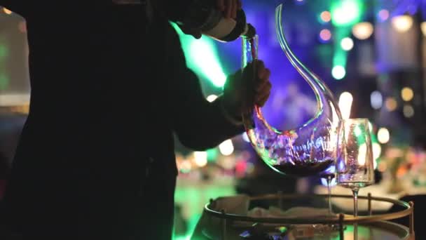 婚礼宴会上 穿着正装的男人拿着一瓶红酒 用优雅的玻璃瓶倒入酒水 为客人准备酒精饮料的人很称职 — 图库视频影像