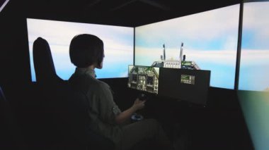 Kadın pilotun uçuş simülatöründe uçak kontrolü uygulaması. Kısa saçlı esmer, gri üniformalı, direksiyonu kontrol eden ve irtifa kazanan..