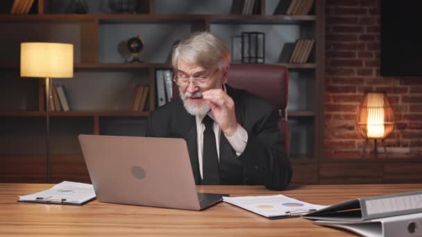 在现代办公室里 戴眼镜自信的老人坐在开着的笔记本电脑后面 用食指指尖着观众 积极的高加索企业家在公司促进新的职业机会 — 图库视频影像