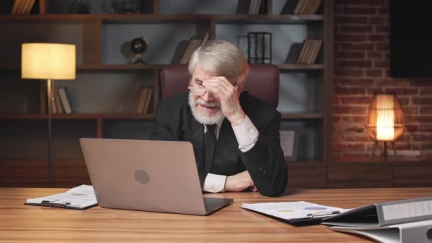 Серьезный Пожилой Человек Очках Расстраивается Глядя Активированный Портативный Компьютер Рабочем — стоковое видео