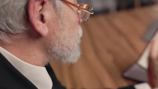 Обрезанный Вид Бородатого Мужчины Очках Перелистывает Страницы Книги Деревянным Столом — стоковое видео