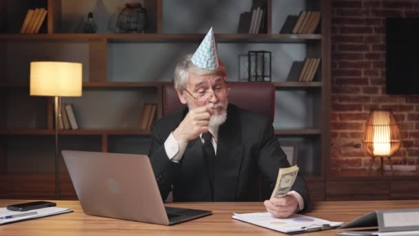 Pozytywny Mężczyzna Kapeluszu Urodzinowym Rozrzucający Banknoty Nad Głową Patrząc Komputer — Wideo stockowe