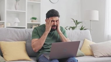 Kötü haberleri okurken elleriyle hareket eden ve yüzüne dokunan sakallı adam. Hintli adam kanepeye oturmuş kablosuz bilgisayarla ve öfkeyle tepki veriyor..
