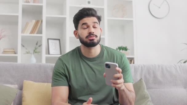 Zoufalý Indián Nervózně Ťukal Obrazovku Smartphonu Zatímco Seděl Pohovce Obýváku — Stock video