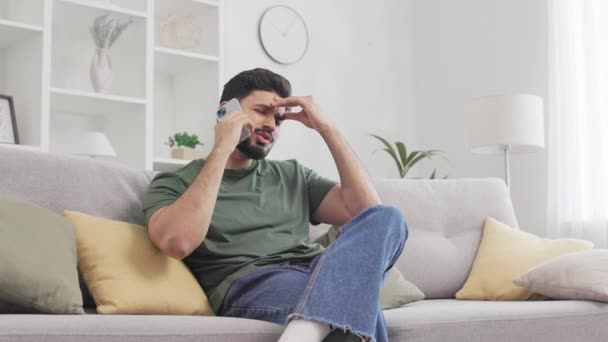 Homem Hindu Irritado Sentado Sofá Cinza Gesticulando Emocionalmente Durante Uma — Vídeo de Stock