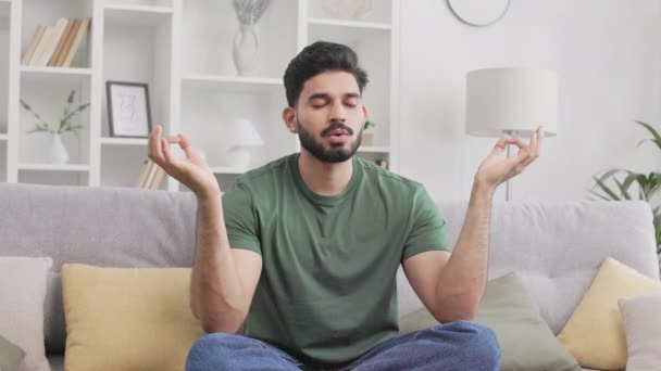 Ruhiger Indischer Mann Freizeitkleidung Sitzt Lotusposition Auf Einer Bequemen Couch — Stockvideo