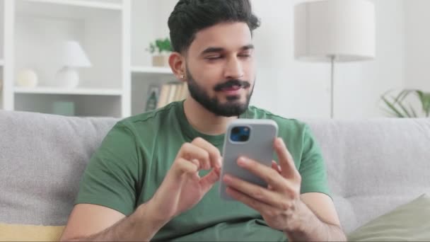 Uomo Indiano Sorridente Guardando Pensieroso Parte Mentre Seduto Sul Comodo — Video Stock