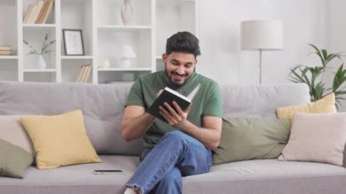Rahat gri koltukta oturan ve kitap okurken parmağını kaldıran heyecanlı Hintli adam. İlham verici sakallı adam yeni fikirle ya da hobi yaparken problem çözümü ile tatmin oluyor..