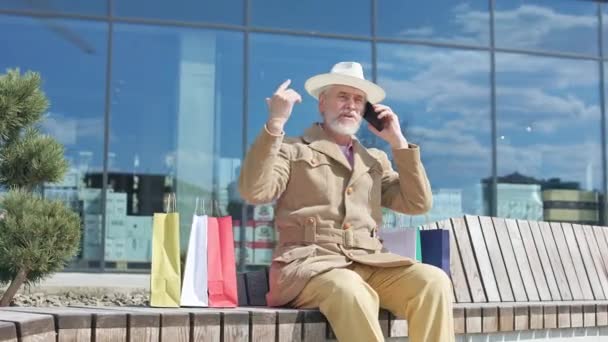Rentnerin Sitzt Vor Einkaufszentrum Und Diskutiert Details Während Sie Mit — Stockvideo