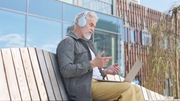 Грамотний Старший Бізнесмен Бездротовими Навушниками Мають Онлайн Відеодзвінок Портативний Ноутбук — стокове відео