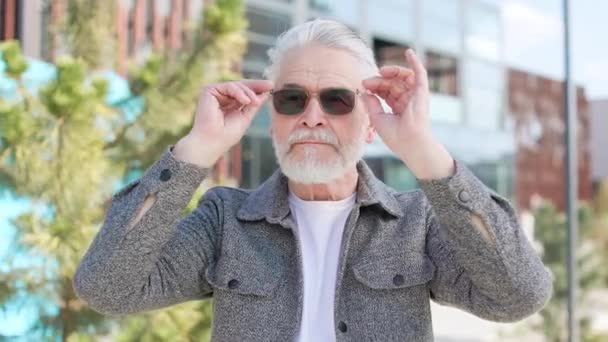Der Grauhaarige Rentner Genießt Seine Neue Teure Sonnenbrille Während Der — Stockvideo