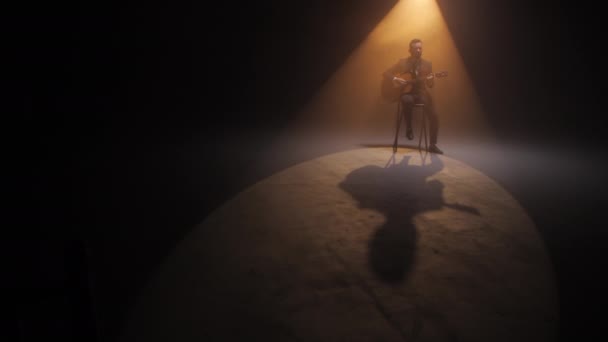 Όμορφος Κιθαρίστας Παίζει Μελωδία Ενώ Κάθεται Κύκλο Από Έντονο Φως — Αρχείο Βίντεο