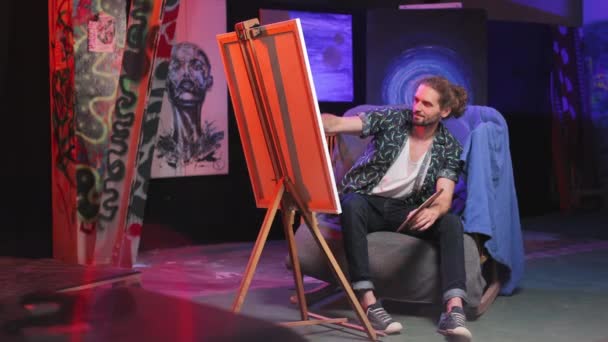 Artista Masculino Imaginativo Sentado Cadeira Confortável Frente Canva Cavalete Ativamente — Vídeo de Stock