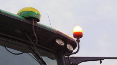 Çeşitli ekipmanların sergilendiği traktörün üst kısmını kapatın. Sağdaki turuncu ışık, soldaki GPS için antenli yeşil ve sarı cihaz..