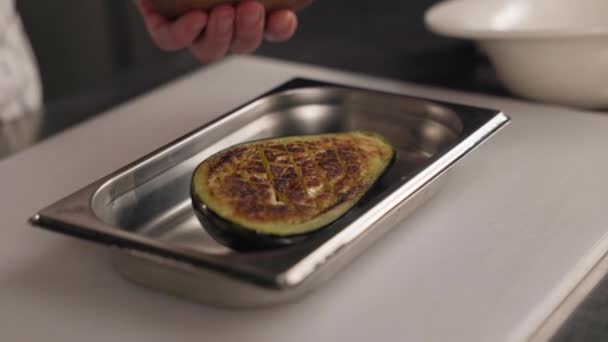 熟练的人用勺子在茄子片上涂上深色的大块酱汁 烤蔬菜放在不锈钢托盘上 专业厨房和室内厨师 — 图库视频影像