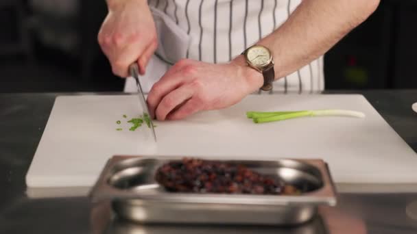 Людина Кулінарному Вбранні Рубає Зелені Трави Білій Обробній Дошці Умілий — стокове відео