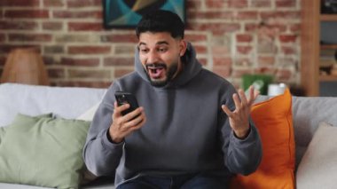 Heyecanlı bir yetişkin, yeni akıllı telefon modeliyle sevinç çığlıkları atarken kazanan el sıkışır. Başarılı bir insan çevrimiçi oyunda başarı kazanır ve birincilik kazanır..