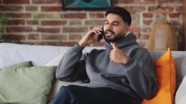 Kendinden emin esmer, uzaktaki meslektaşıyla iletişim kuruyor ve evde el kol hareketi yaparken süreci telefonla açıklıyor. Sakin bir insan, yastıklı koltukta otururken uzaktan iş arkadaşına talimat verir..