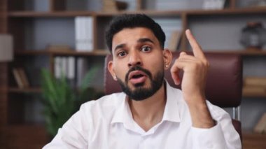 Beyaz gömlekli yetenekli adam tavanı işaret ediyor. Ofis ortamında fikir sahibi olduğunu gösteriyor. İçerideki projeyi düşünen yakışıklı Hintli adam. İş yeri ve meslek kavramı.