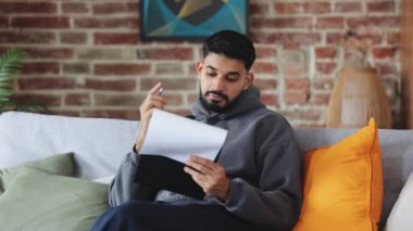 Tablete yapışmış kağıda yazı yazan Arap sakallı bir adam ve duvarın arkasına hafifçe gülümseyen bir adam. Kontrat üzerinde çalışan ve ortaklık şartlarını ve koşullarını kontrol eden sıradan kişi.