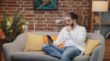 Bir keresinde beyaz gömlekli, kanepeye oturmuş akıllı telefon ekranını dinleyen tuhaf bir beyaz adam. Kaşlarını kaldırıyor ve ağzını hafifçe kapatıyor. Beklenmedik haberler ya da şok edici gelişmeler beni şaşırttı..