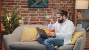 Beyaz gömlekli sinirli bir adam kucağında dizüstü bilgisayarla koltukta oturmuş hayal kırıklığı içinde alnına tokat atıyor. Hata yaptıktan sonra gözlerini kapatıp dişlerini gıcırdatmak. Başarısızlığa veya gerilemeye duygusal tepki vermek.