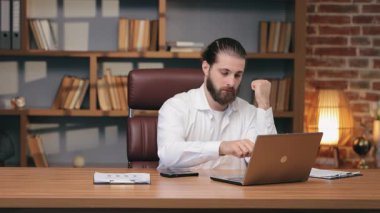Çekici beyaz erkek, dizüstü bilgisayara gülümserken ellerinin önünde duruyor. Klavyede daktiloyu bitiriyorum. Metin giriliyor. Modern teknoloji konsepti. Sohbet sırasında sıcak tepki.