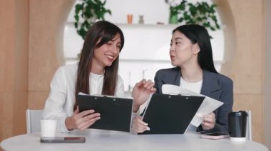 Muhabbetin ortasında elinde dosya tutarak gülen iş arkadaşları fikir alışverişinde bulunuyordu. Düşünceleri paylaşmak ya da rahat takım oturumunda gelişigüzel geri bildirim vermek. Etrafı telefon ve kahve ile çevrili..