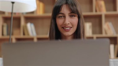 Beyaz tenli güzel bir kadın ekrana bakıyor ve açıkça konuşuyor. Canlı toplantıya katılmak ya da özel dersler kaydedilirken kendine güveni ve arkadaş canlısı yüz ifadesini korumak.